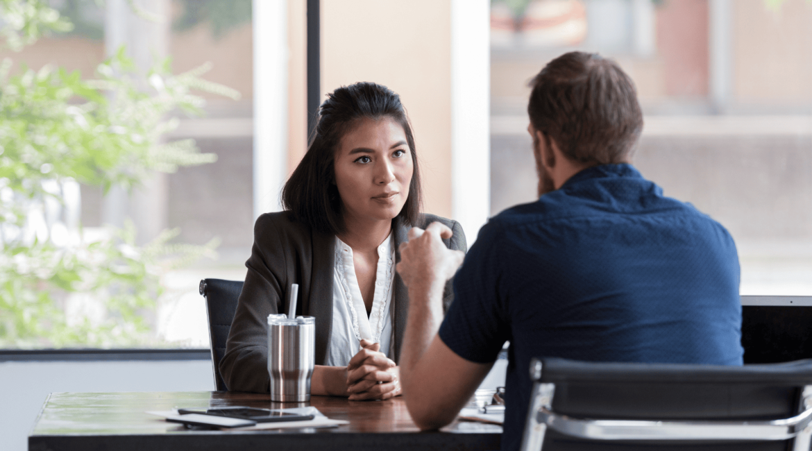 A leader attentively listening to a coworker during a discussion in a professional setting.