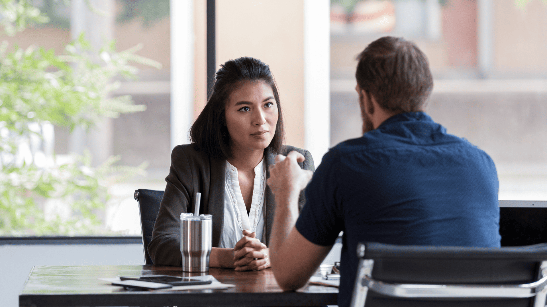 A leader attentively listening to a coworker during a discussion in a professional setting.