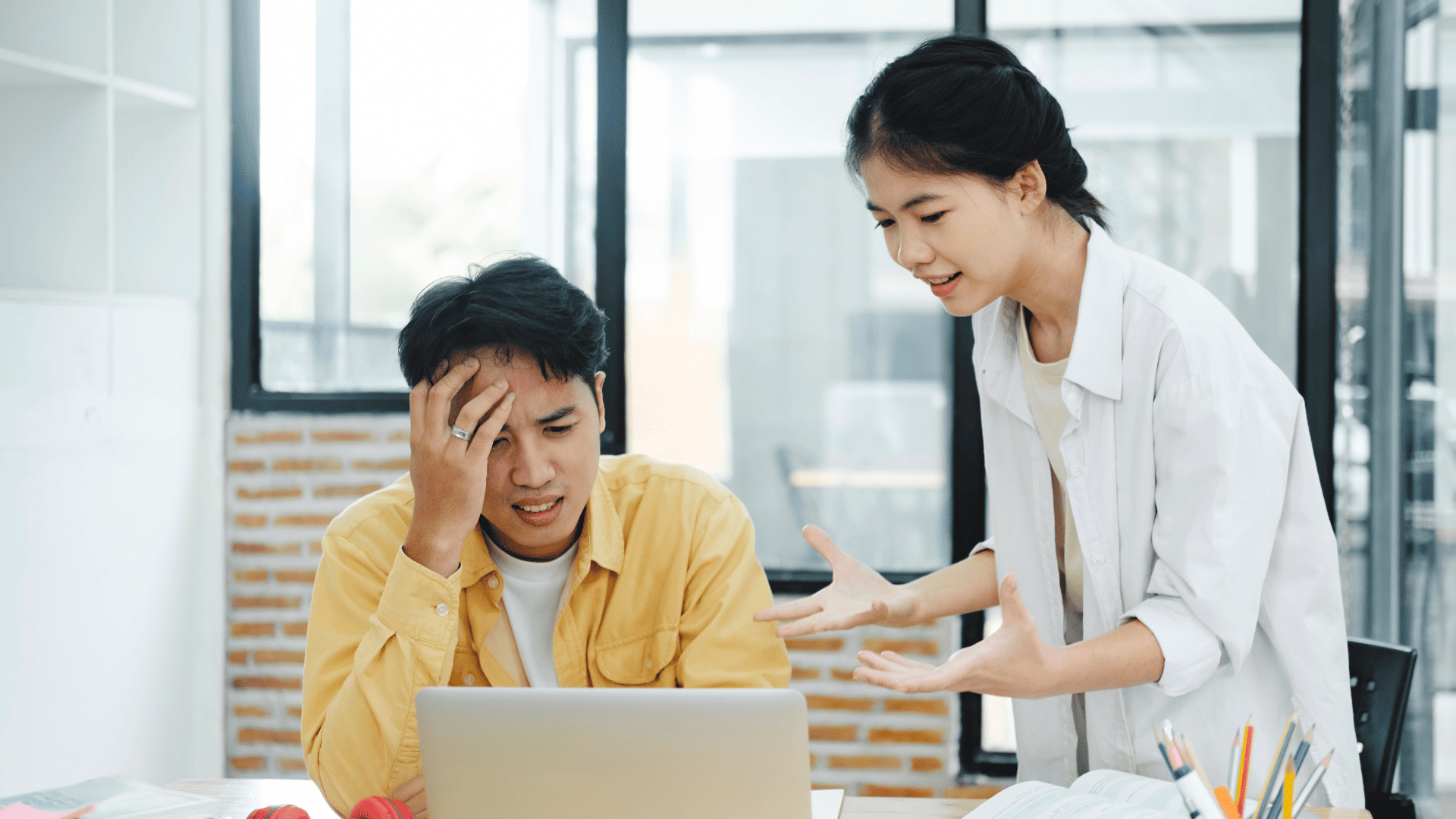 A millennial employee looking confused while discussing with a Gen Z colleague, who is confidently explaining something in a workplace setting.